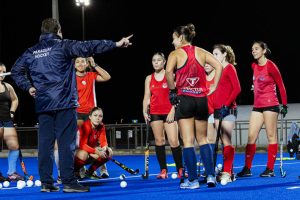 Equipo de hockey estirando en la vuelta a la calma tras el entrenamiento