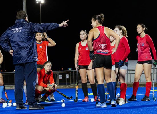 Equipo de hockey estirando en la vuelta a la calma tras el entrenamiento